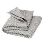 Folded textured gray blanket on a white background